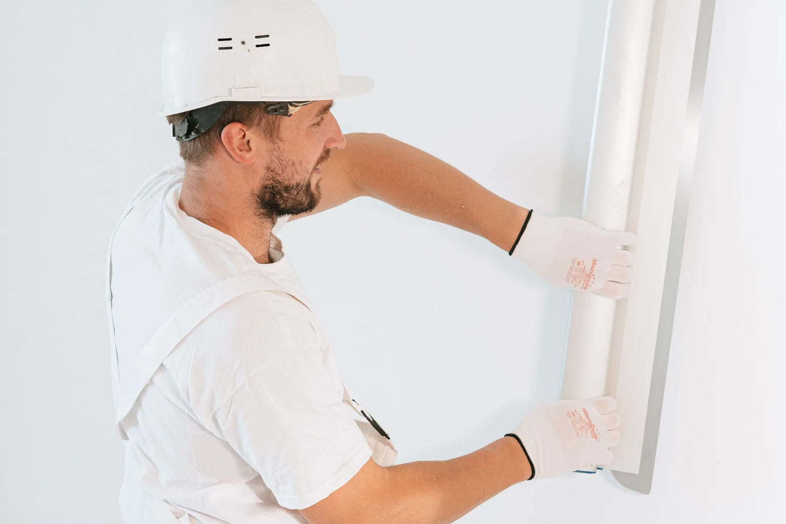 Vakman brengt stucwerk aan op een wand